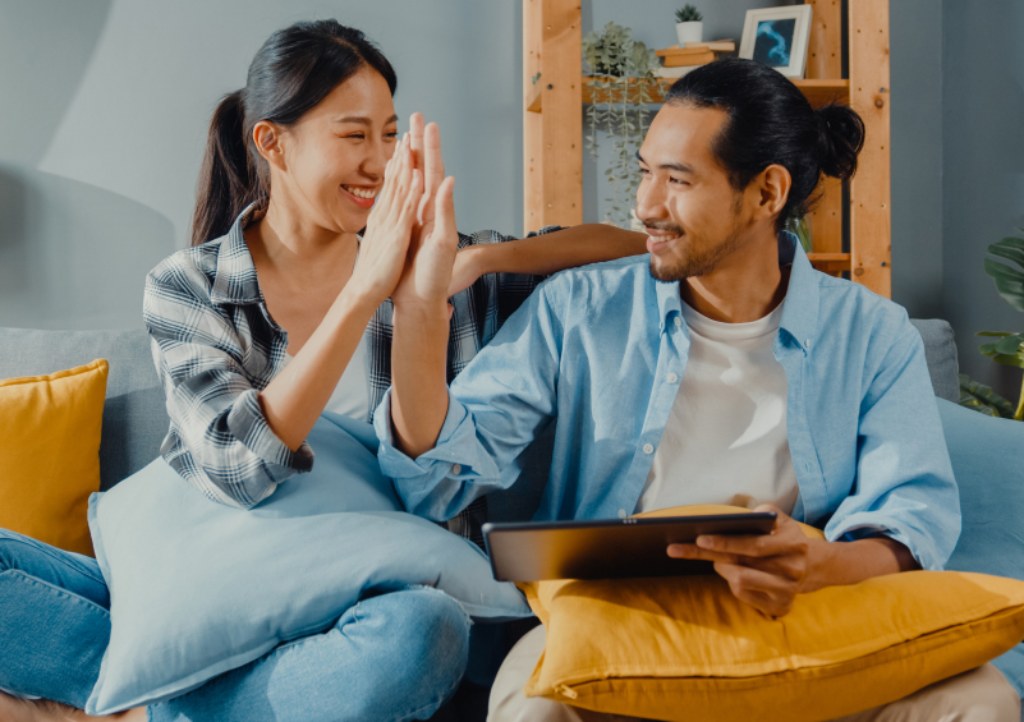 A man and woman sitting giving a high-five