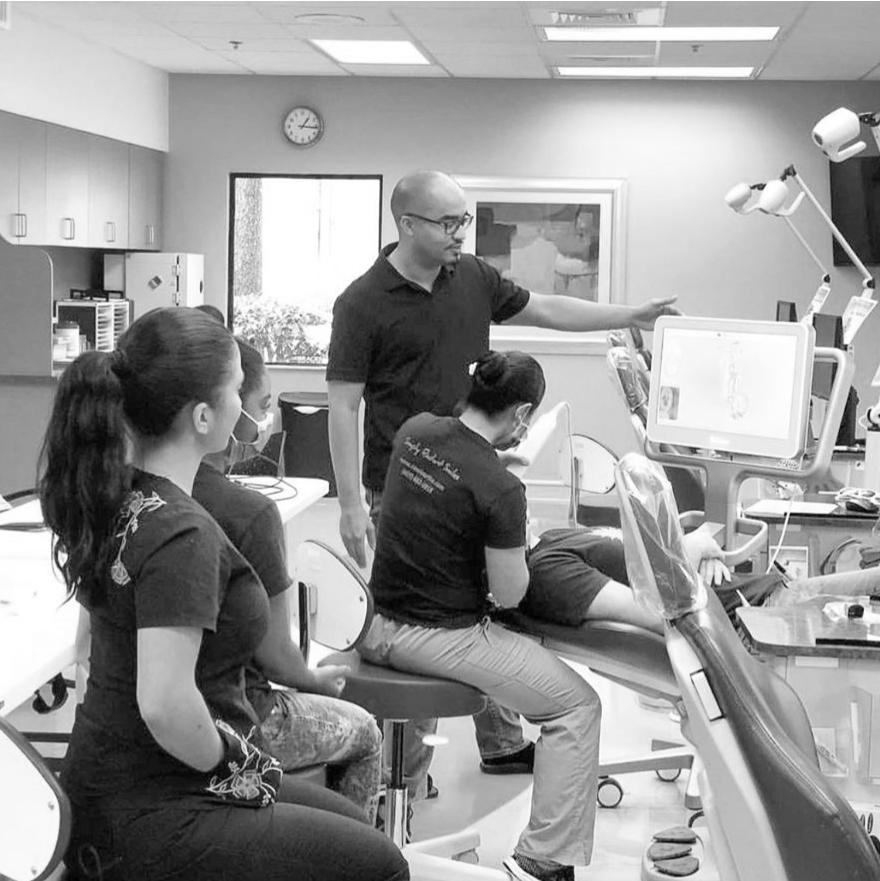 Dr. Rawle showing a screen to a patient and two team members