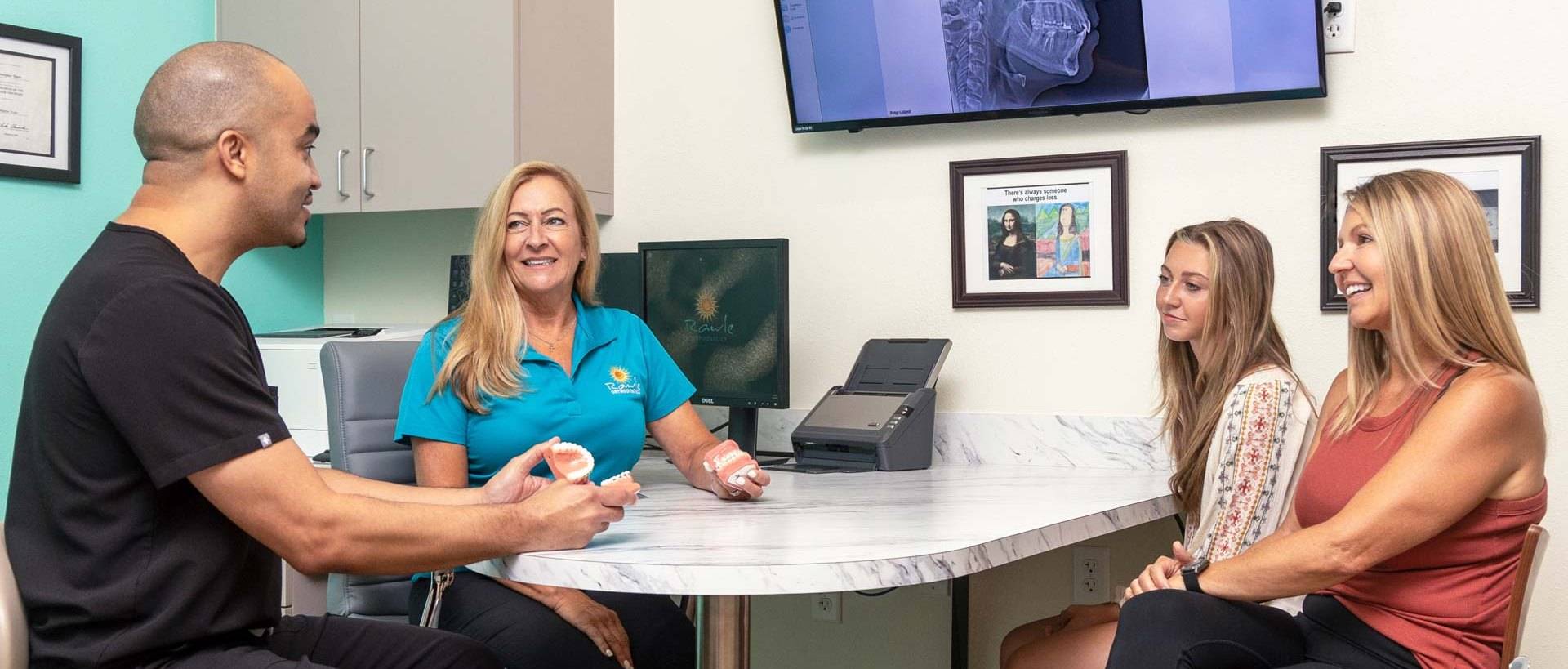 Rawle Orthodontics consultation with clear aligner model and patient family.